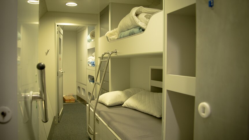 An unoccupied ship's cabin with a double bunk-bed.