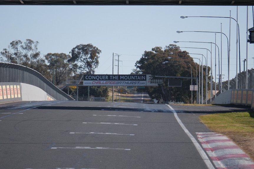 bitumen race track with signs and barriers either side of road 