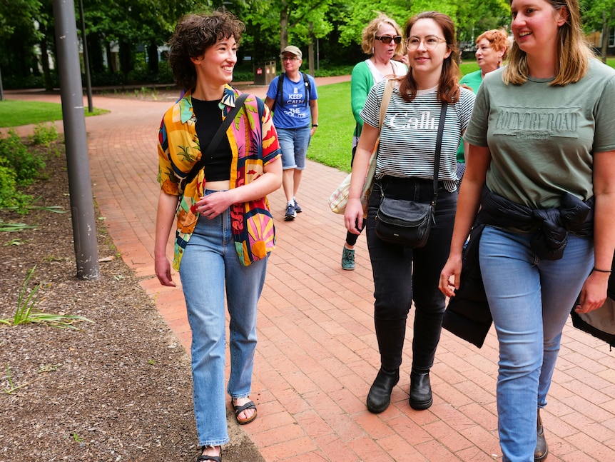 A group of women walking through a park. 