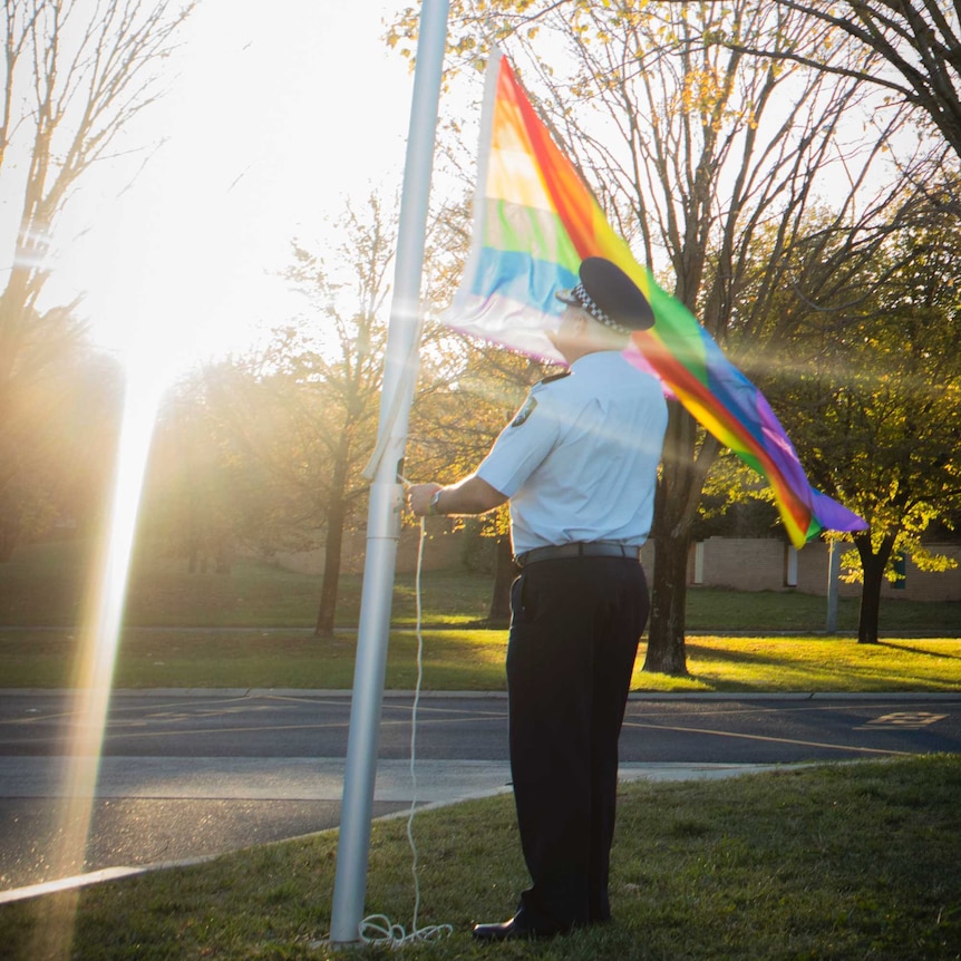 Chief Police Officer Rudi Lammers raising a rainbow flag in support of Canberra's LGBTI community.