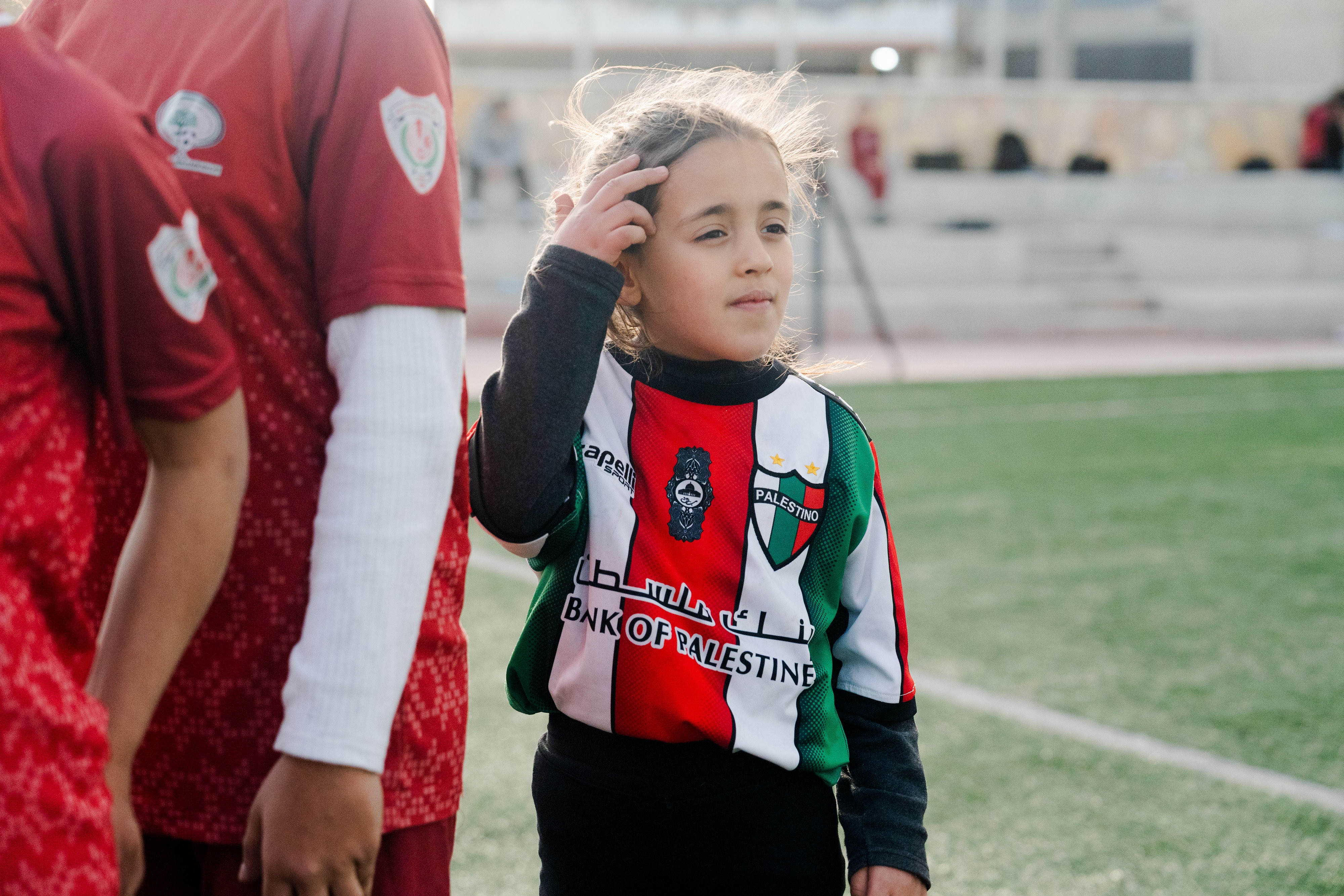 Un primer plano de una joven con una camiseta palestina en el campo de fútbol.