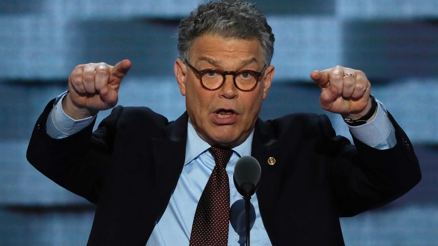 Al Franken stands on a stage