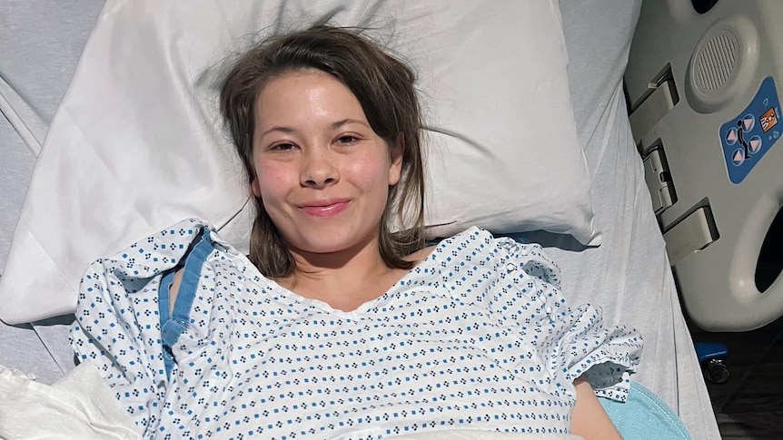 A young woman lying in a hospital bed.