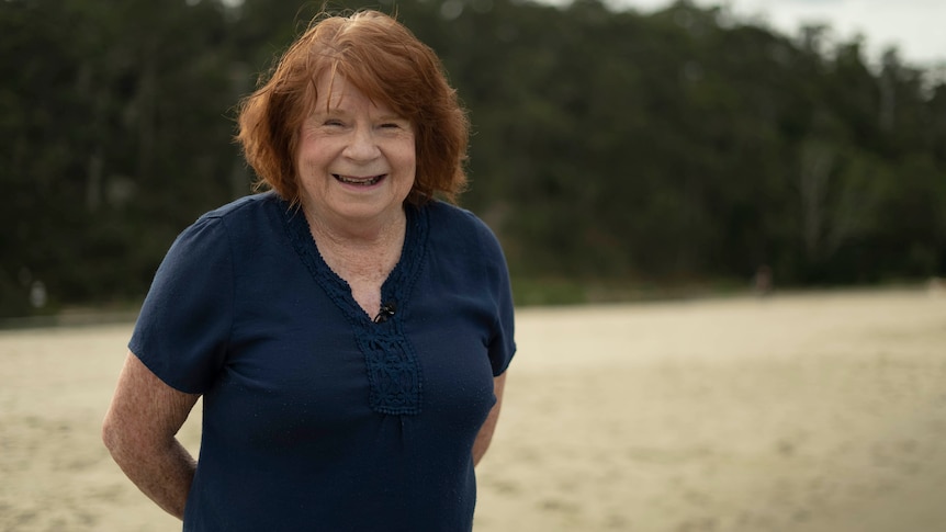 A woman smiling at the beach.