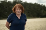 A woman smiling at the beach.