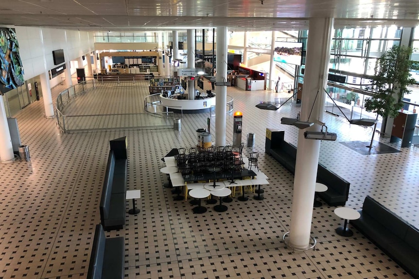 Chairs and tables are stacked in an empty terminal.