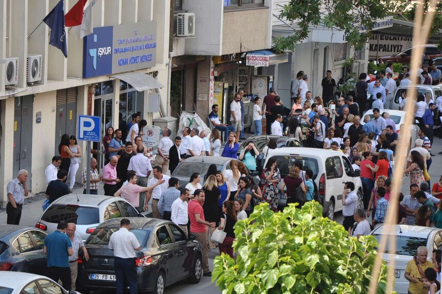 People gather in the streets of turkey assessing the damage of an earthquake in a business centre