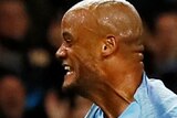 Vincent Kompany clenches his fists and runs towards the crowd in celebration