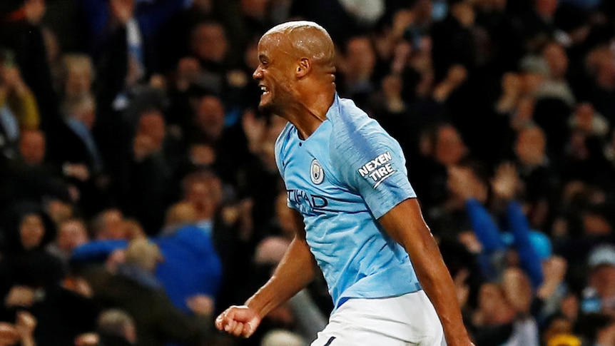 Vincent Kompany clenches his fists and runs towards the crowd in celebration