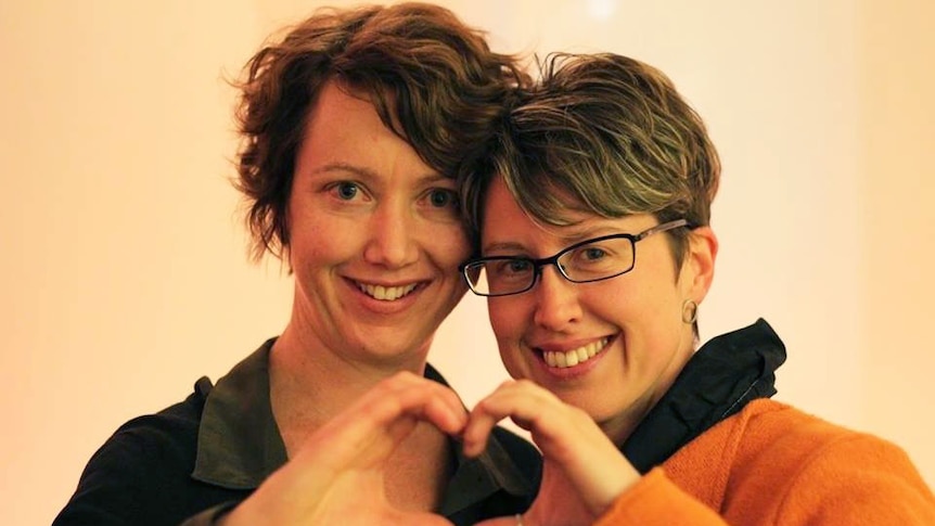 Kylie Walker and her partner Anita Dwyer form a love heart with their hands.