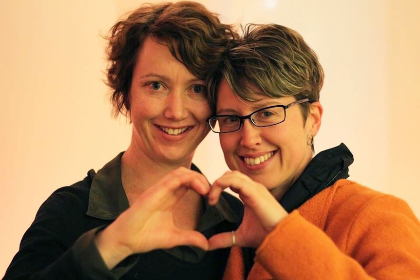Kylie Walker and her partner Anita Dwyer form a love heart with their hands.
