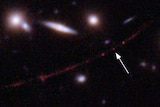 A slightly blurry image of a small group of distant stars, with an arrow pointing to one of them.