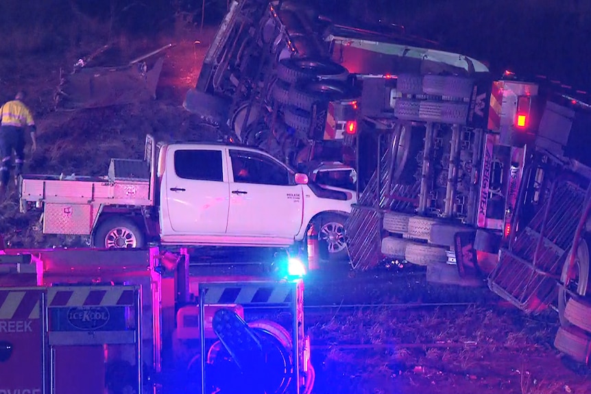 Truck rolled onto its side with emergency vehicles