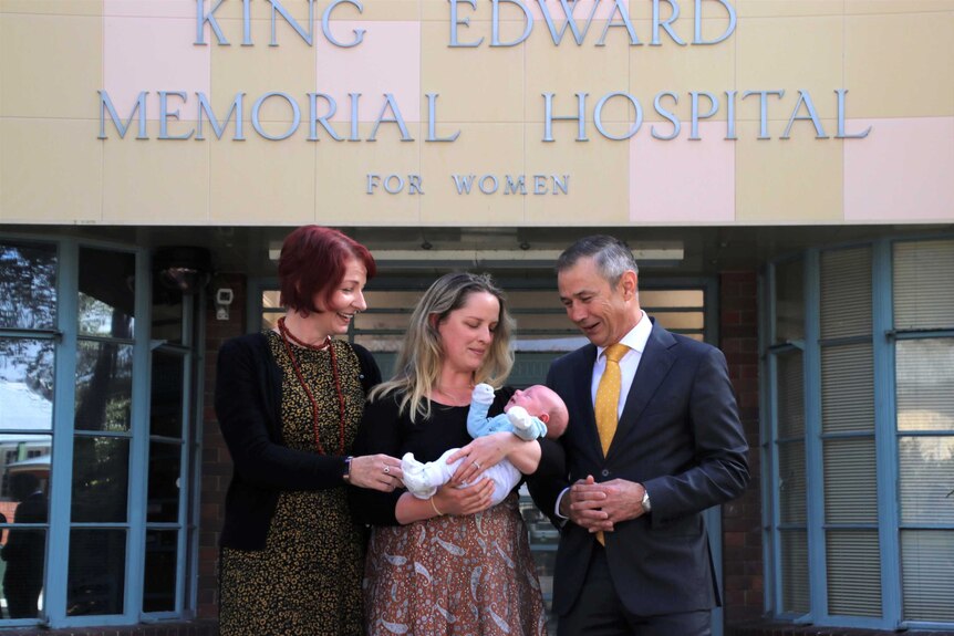 A group photo of Clare Davison, Emily Slattery, baby George and Roger Cook outside King Edward Memorial Hospital.