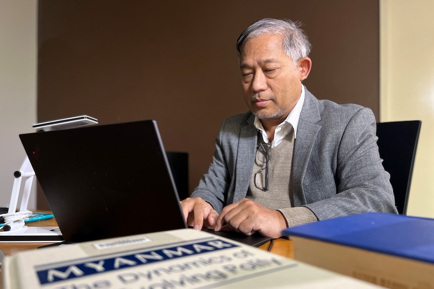 Dr Tun Aung Shwe types on his computer
