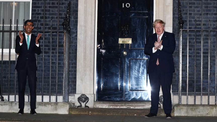 Britain's Prime Minister Boris Johnson and Chancellor of the Exchequer Rishi Sunak applaud outside 10 Downing Street.