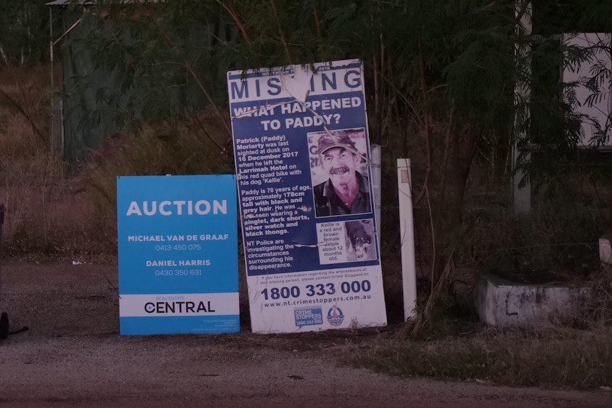 A photo showing rubbish bins next to autiion sign and a missing person sign
