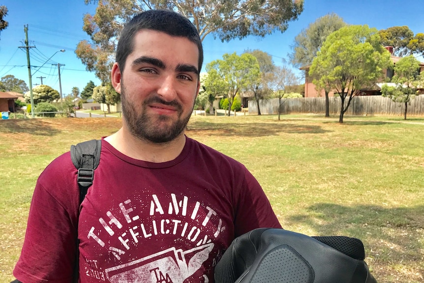 23-year-old Rhys smiles for the camera in a Melbourne park