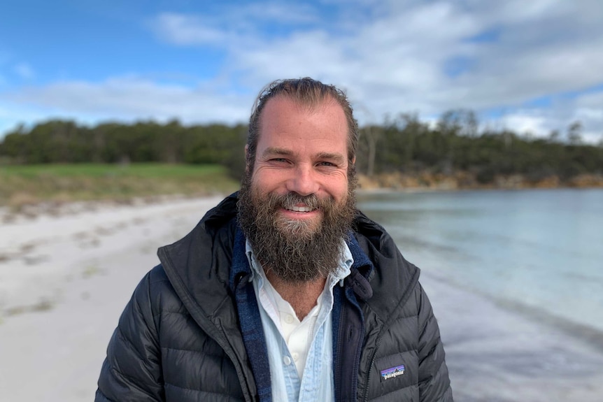 Man with beard standing on beach