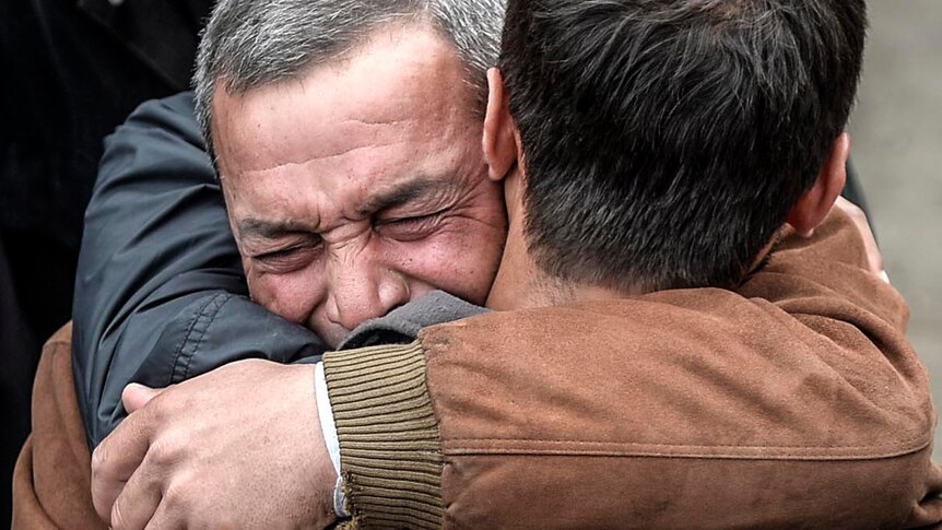 Two men embrace after news of the death of a relative following an explosion in the Soma coal mine.
