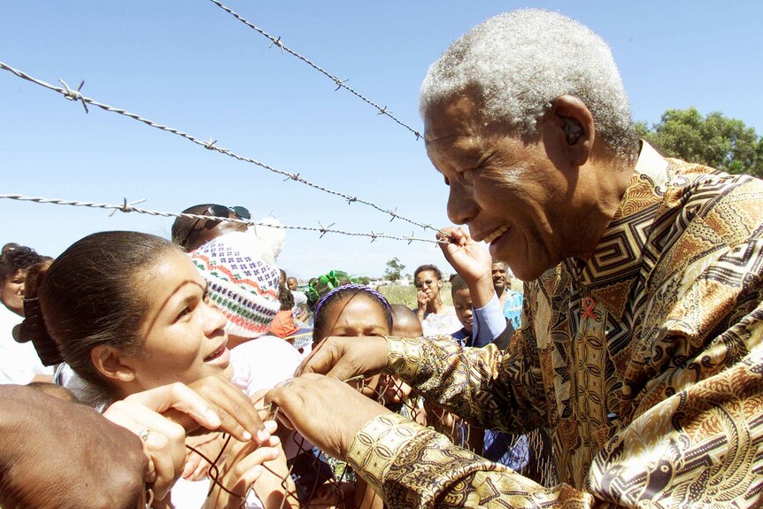 Nelson Mandela greets children during a visit to Eerste River township near Cape Town on November 28, 2000.