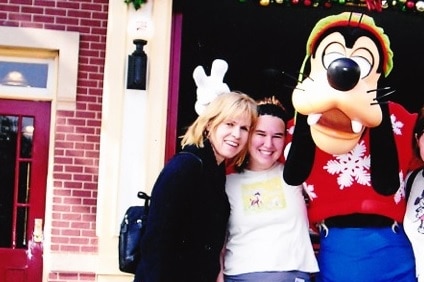 Robyn Pettigrew and Miranda Howard pose for a photo with a character at Disneyland.