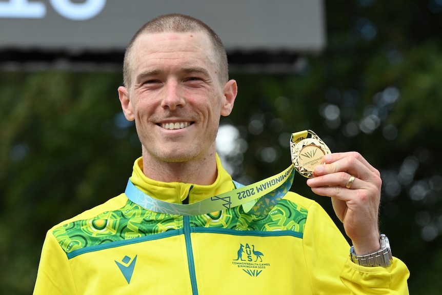 Australian cyclist Rohan Dennis holds up a gold medal after the Commonwealth Games time trial.