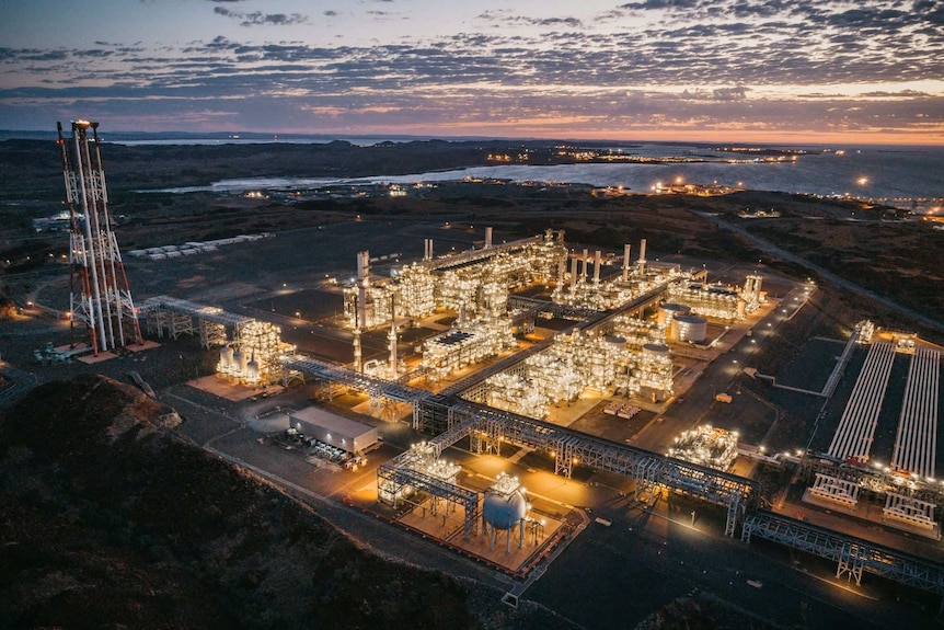 A vast industrial site lit up at dusk.