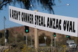 A white sign that says "U aren't Gunner steal ANZAC Oval"