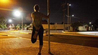 A woman stretches before a night run