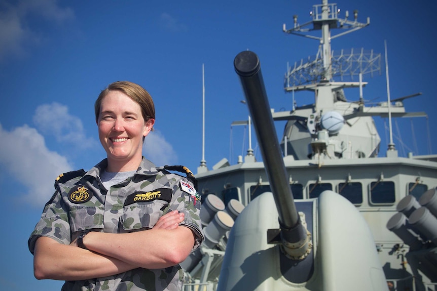Garbutt smiles at the camera from HMAS Arunta's bow.