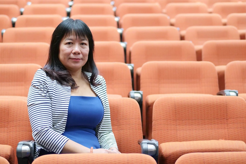 Professor Fang Chen sits in an empty lecture hall, May, 2020.