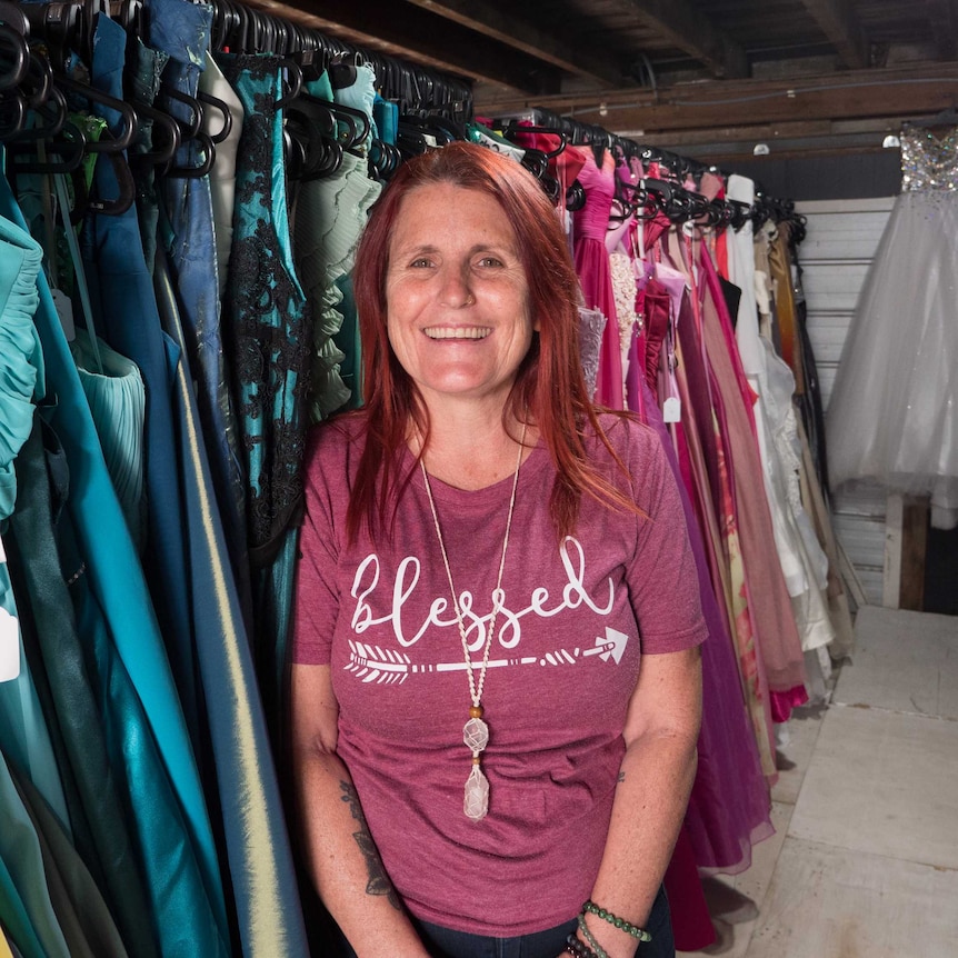 Tammy standing in front of the donated formal gowns