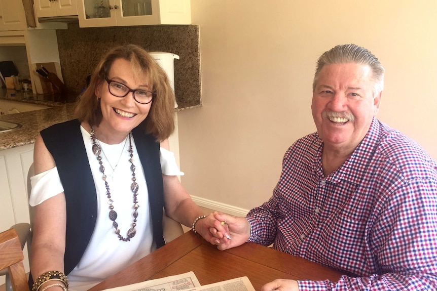 Debbie and Gary sitting at a table smiling.