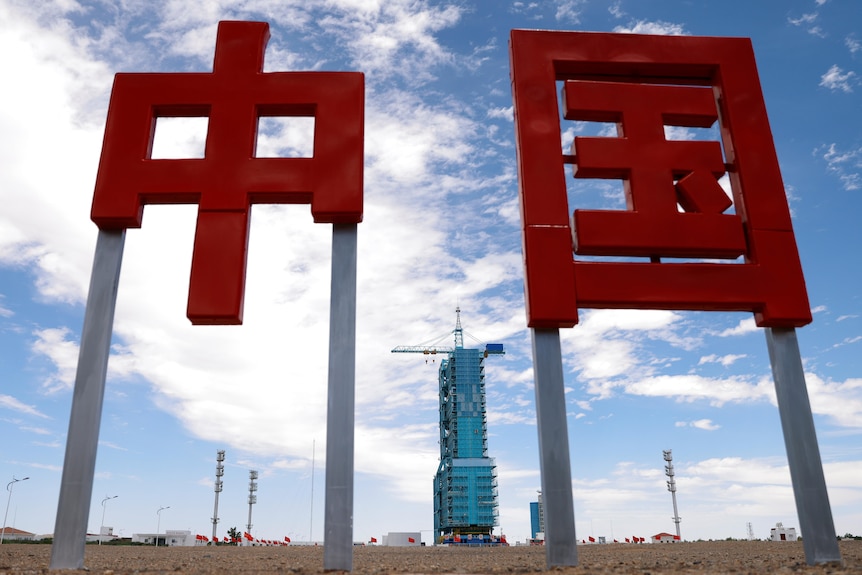 The launch pad for the Long March-2F Y12 rocket is seen behind Chinese characters of "China" at Jiuquan Satellite Launch Center.