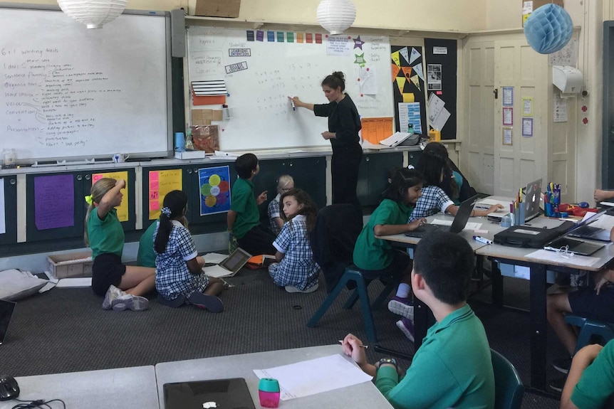 Bethany Corrigan pointing to a whiteboard as she teaches her class