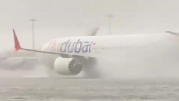 A plane on a runway with high water around it