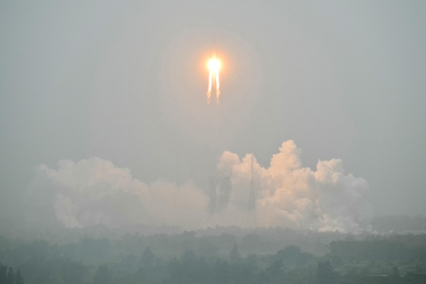 A rocket takes off into the sky with flames at its tail