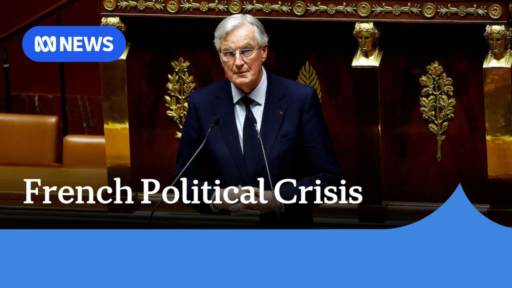 French Political Crisis: A man with grey hair, wearing a suit and tie speaking into a pair of microphones.