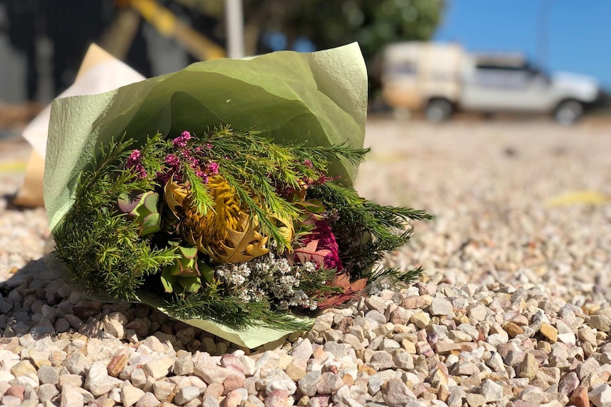 A bunch of flowers left near the scene of a fatal helicopter crash in Broome.