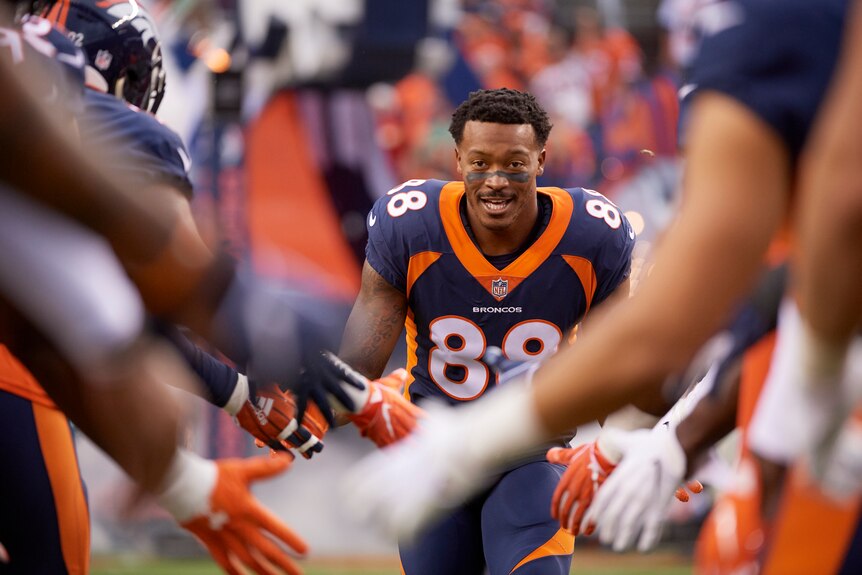 Denver Broncos Demaryius Thomas running past his teammates giving high-fives before a match 