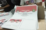 A small stack of ballot papers printed with Indonesian language.