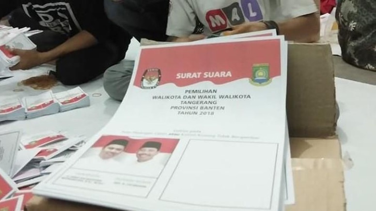 A small stack of ballot papers printed with Indonesian language.