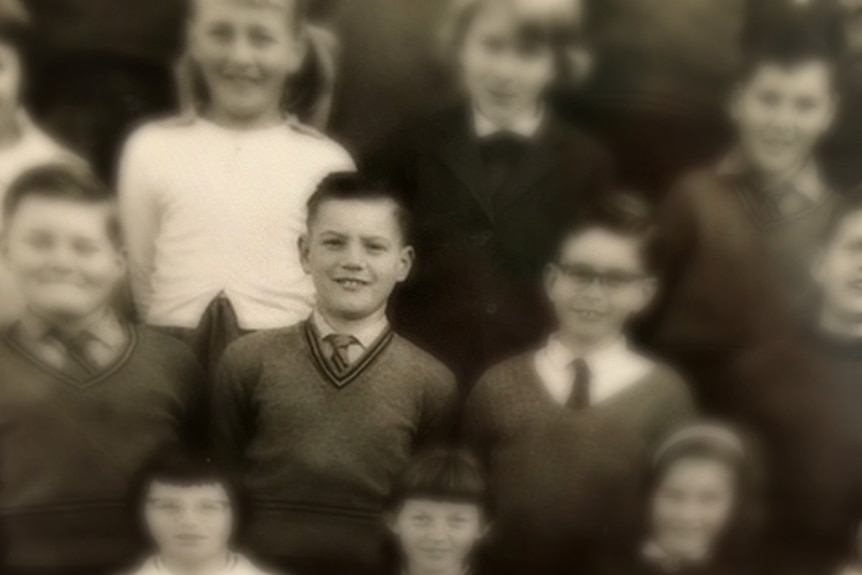 Black and white photo of a boy in grade four in school uniform.