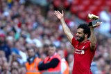 Liverpool's Mohamed Salah lifts up his golden boot award after his side's win over Brighton.