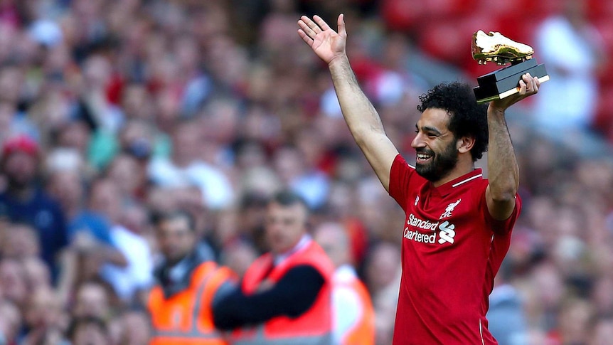 Liverpool's Mohamed Salah lifts up his golden boot award after his side's win over Brighton.