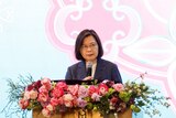 台湾总统蔡英文站在饰有鲜花的讲台上