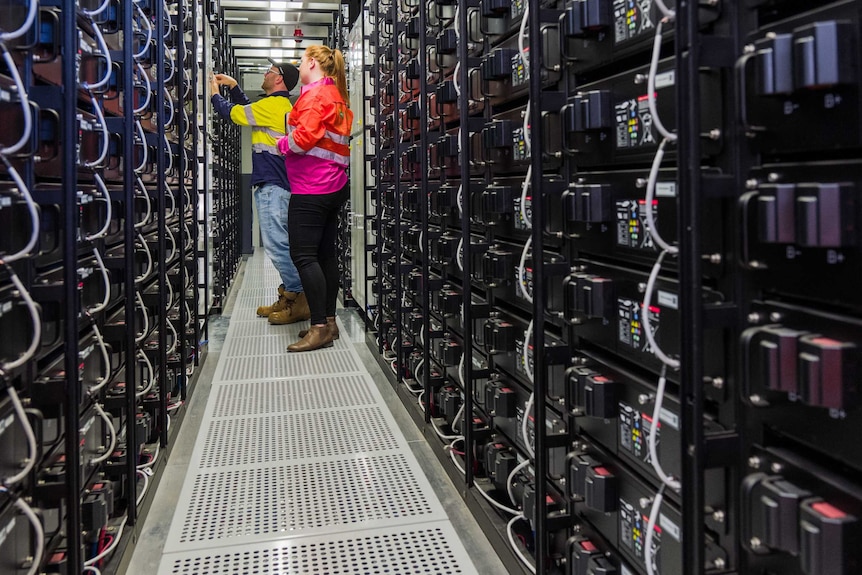 Facility with two workers near storage batteries.