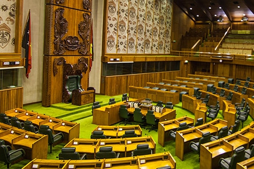 An image of a parliament room with desks and chairs in a circular fashion