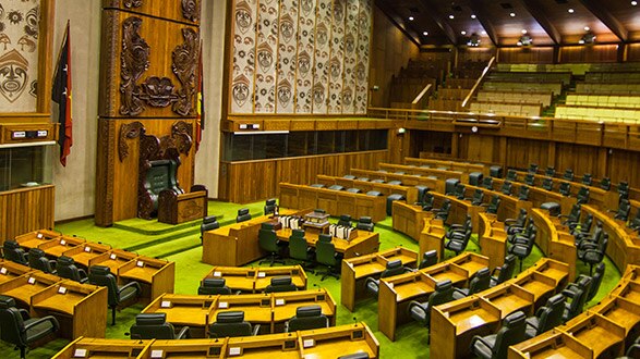 An image of a parliament room with desks and chairs in a circular fashion
